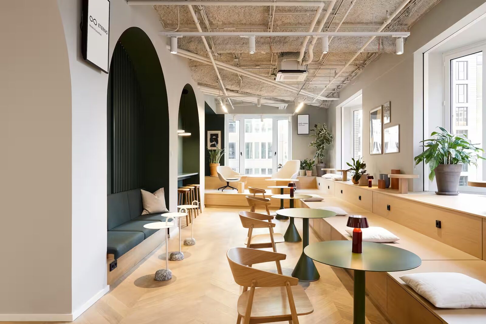 Wartebereich mit Sitznischen und Café-Tischen bei Eterno Hamburg