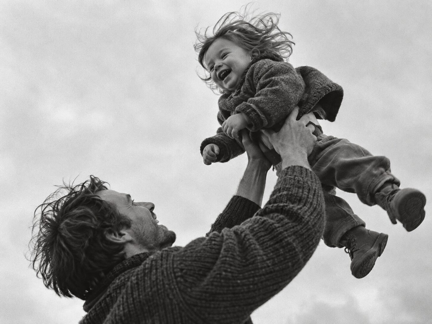 Vater hebt lachendes Kind in die Luft